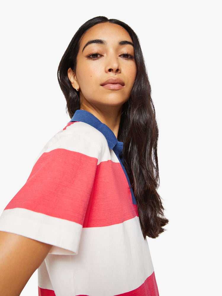 Close up view of a woman in a collared top with short sleeves, a V-neck and a loose fit.
