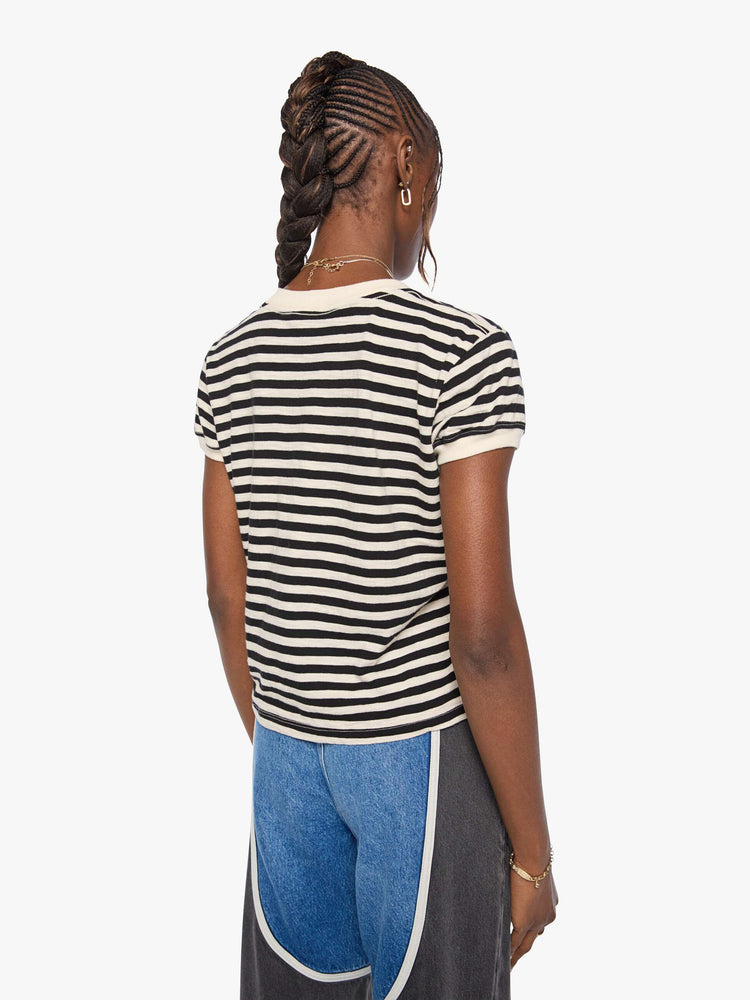 Back view of a woman in a black and cream stripes tee features a mouth patch with MOTHER's name in yellow on the hip.