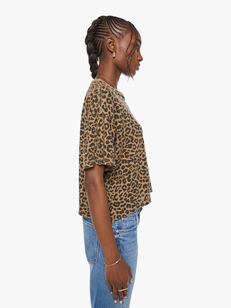 Side view of a woman in cheetah cropped crew neck tee with drop shoulders, short sleeves and a boxy fit.