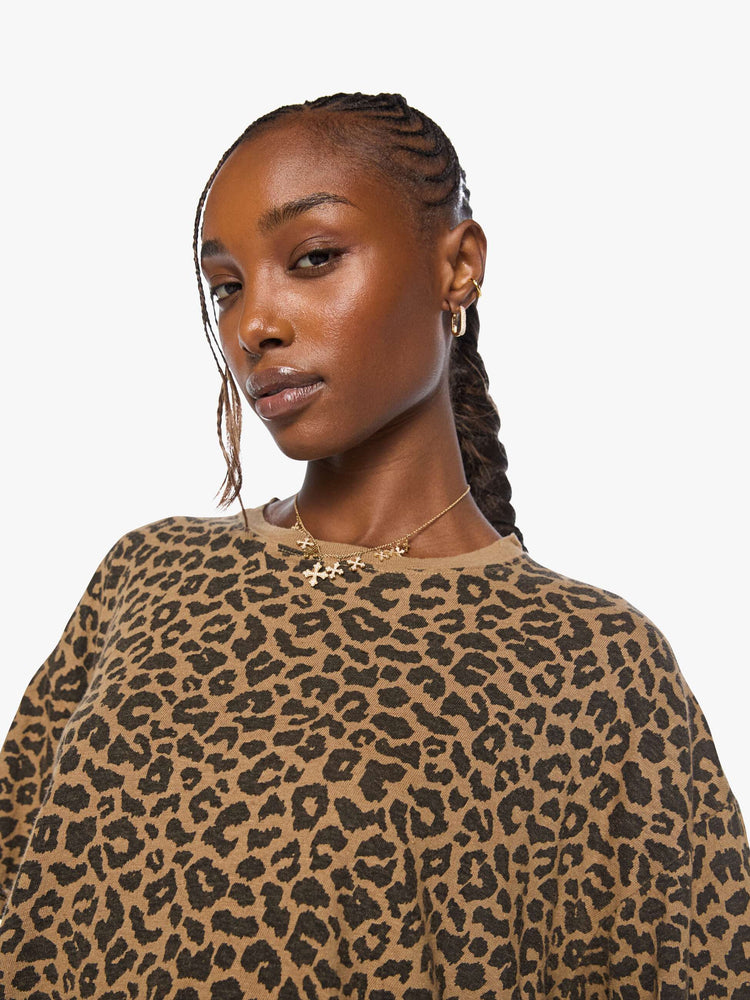 Close up view of a woman in cheetah cropped crew neck tee with drop shoulders, short sleeves and a boxy fit.
