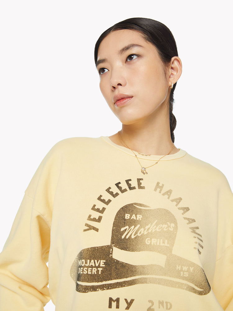 Close up view of a woman crewneck sweatshirt with dropped sleeves and relaxed fit in a pastel yellow.