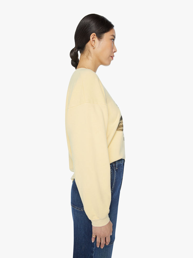 Side view of a woman crewneck sweatshirt with dropped sleeves and relaxed fit in a pastel yellow.