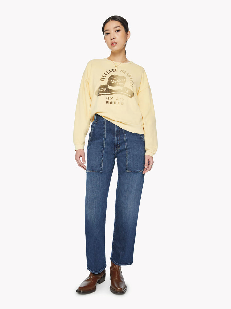 Full body view of a woman crewneck sweatshirt with dropped sleeves and relaxed fit in a pastel yellow.