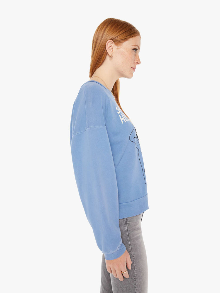 Side view of a womens faded blue sweatshirt featuring a front graphic.