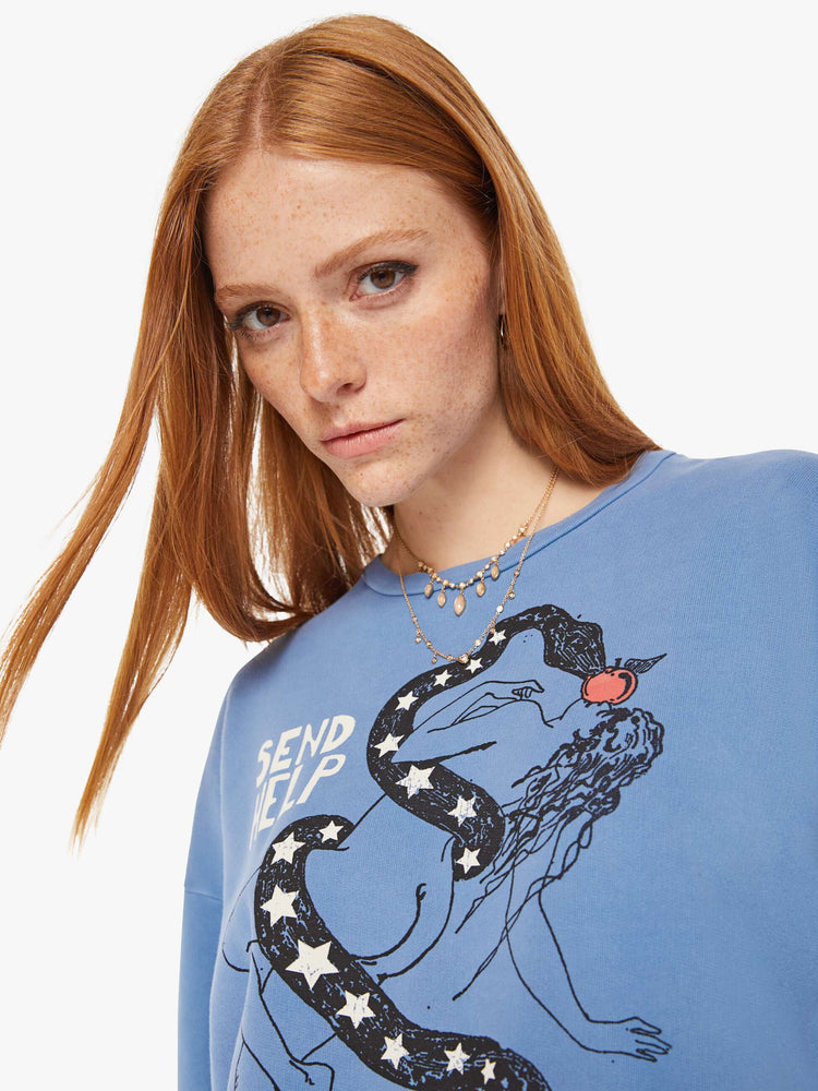 Front close up view of a womens faded blue sweatshirt featuring a woman and snake graphic with the words "SEND HELP".