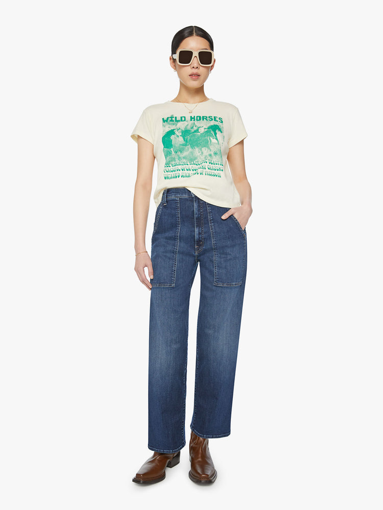 Full body view of a woman off white with faded green graphic horses crewneck slit fit tee.