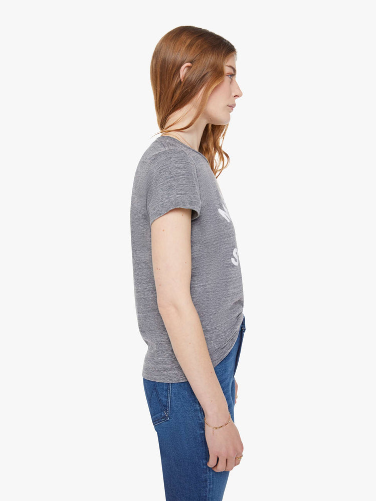 Side view of a woman in  heathered grey tee features white block text on the front.