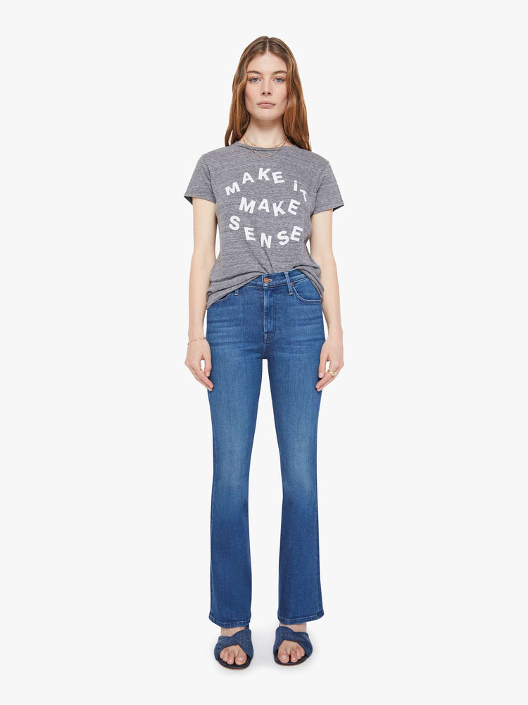 Full body view of a woman in  heathered grey tee features white block text on the front.