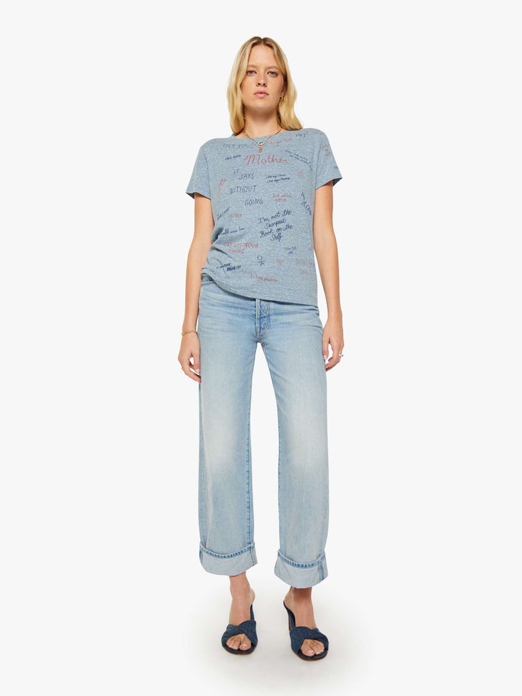 Full body view of a woman in an overdyed blue with a printed text tee.