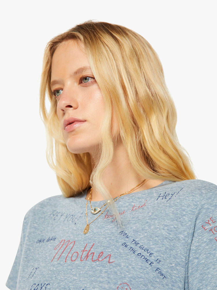 Close up view of a woman in an overdyed blue with a printed text tee.