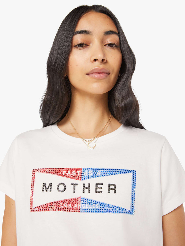 Close up view of a woman in a faded red and blue graphic embellished with metallic rhinestones and MOTHER across the front white crewneck tee.