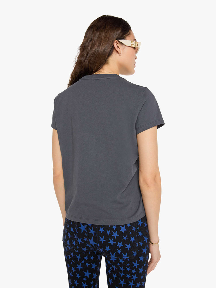 Back view of a woman in faded black tew with a smiley-face graphic and flocked text in white across the chest.