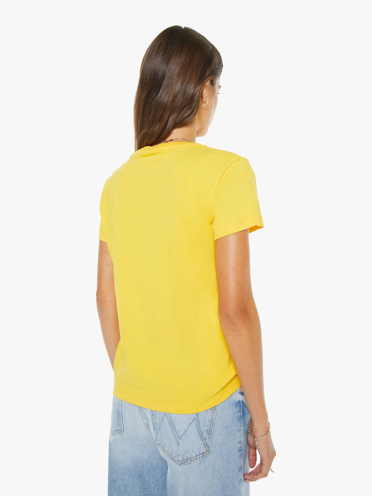 Back view of a woman in a  yellow tee with a blue text graphic on the front.