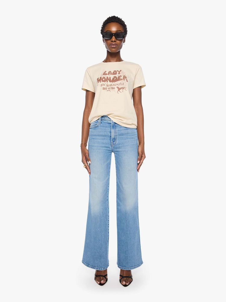 Full body view of a woman in a cream tee with a vintage-inspired Western graphic across the chest.
