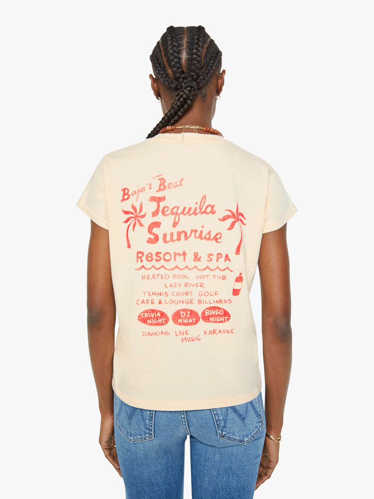 Back view of a woman in a pale peach tee with a mermaid, palm tree and text in faded black on the front and in orange on the back.
