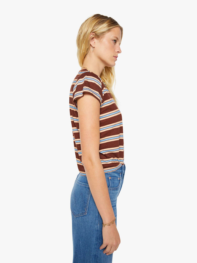 Side view of a woman in a brown tee with printed horizontal stripes in cream and light blue.