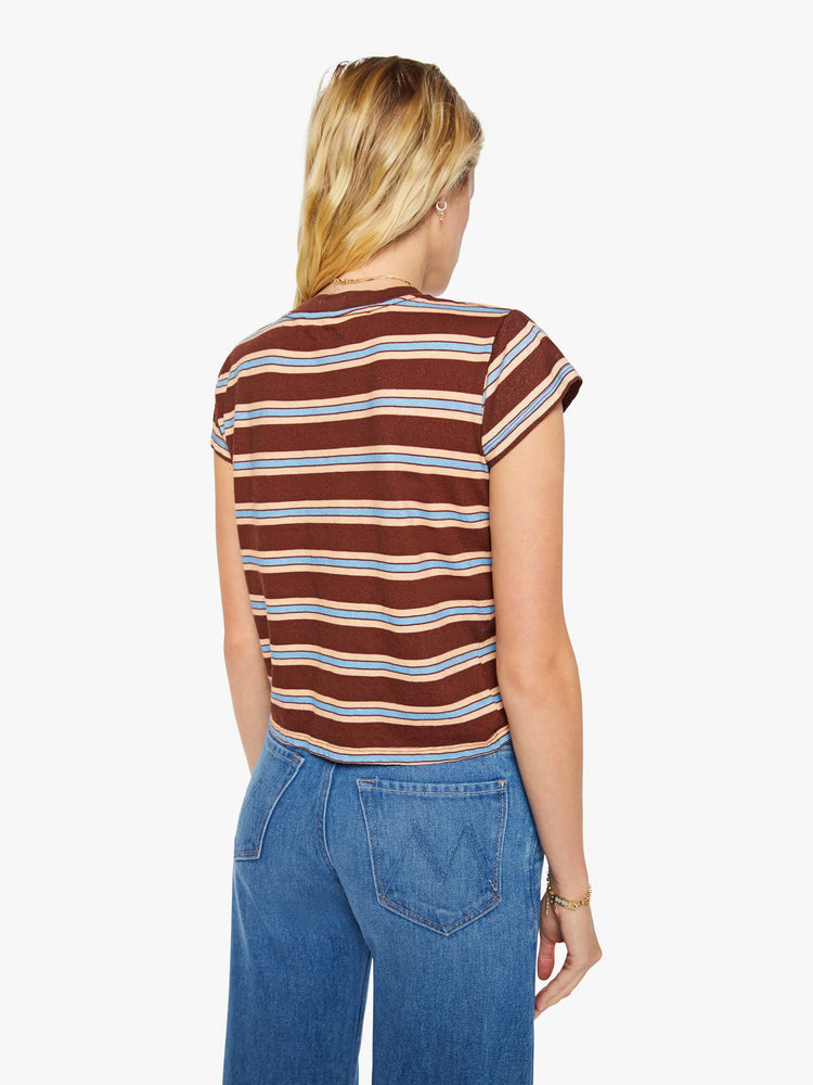 Back view of a woman in a brown tee with printed horizontal stripes in cream and light blue.