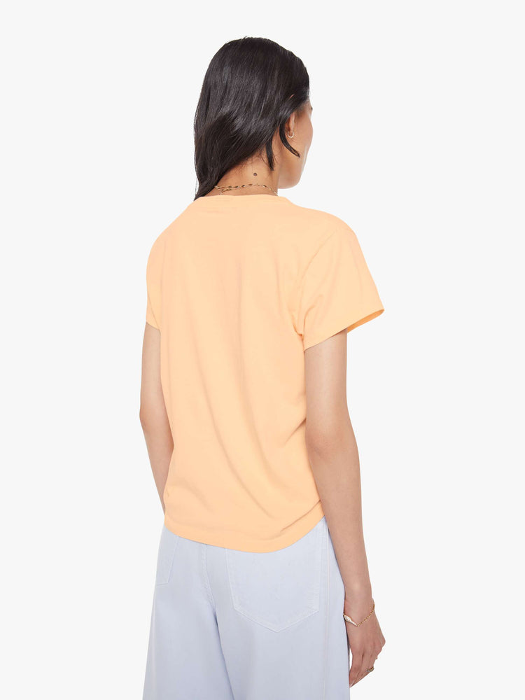 Back view of a woman in light peach, the tee features a black dog graphic with text on the front.