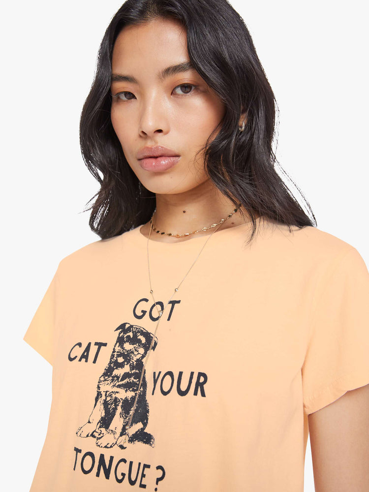 Close up view of a woman in light peach, the tee features a black dog graphic with text on the front.