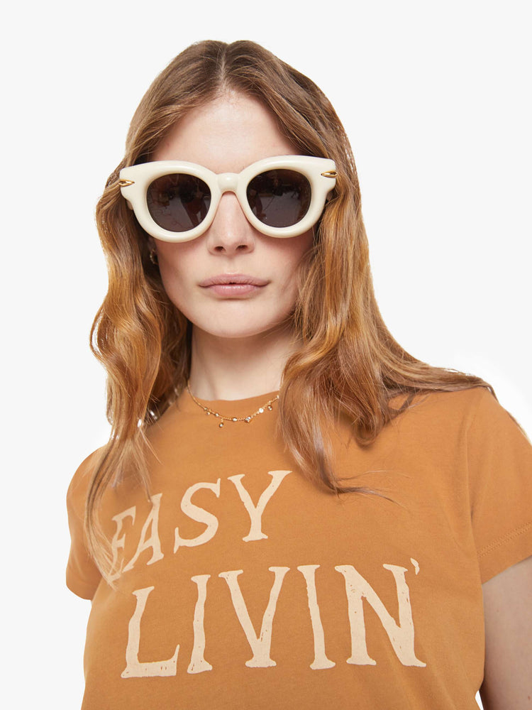 close up view of a woman in a dark khaki tee with cream writing.