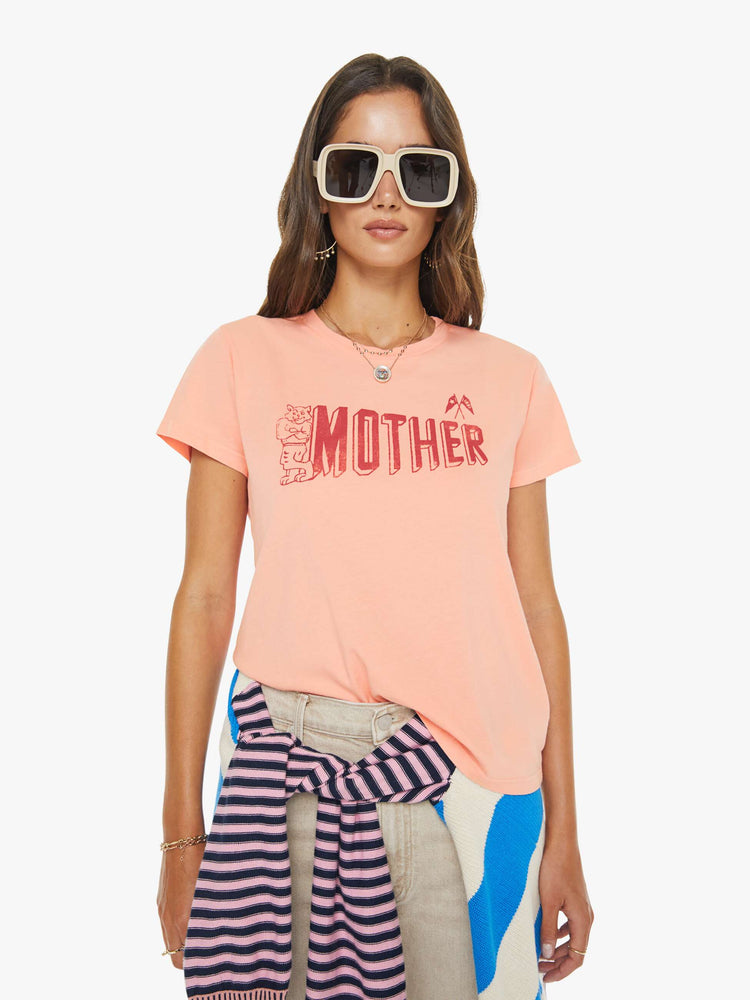 Front view of a woman in a peach tee features a small cat and MOTHER's name in red on the front.