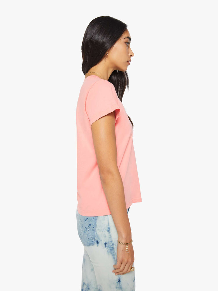 Side view of a woman in pink tee with a black cursive text graphic on the front.