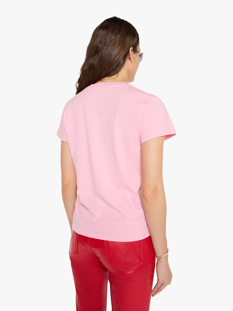 Back view of a woman in a baby pink tee with a text graphic in black across the front.