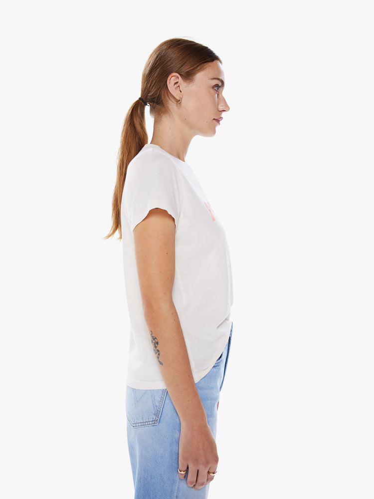 Side view of a woman white crewneck with baby pink text on the front.