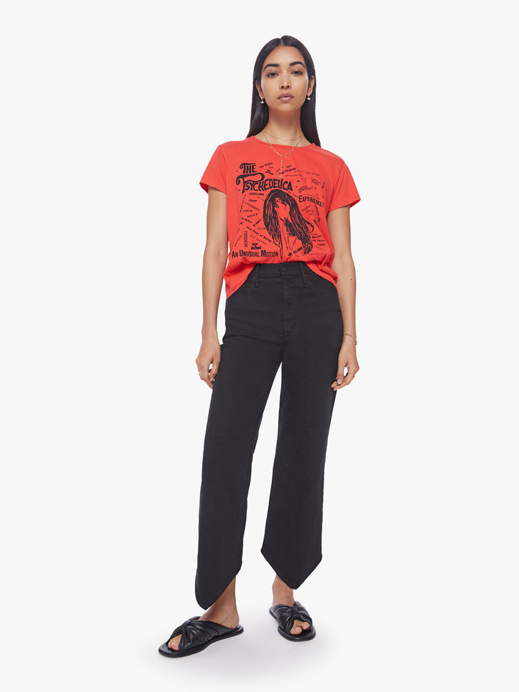 Full body view of a woman bight orange-red hue slim fit crewneck with a graphic portrait and ways to trip out on the front.