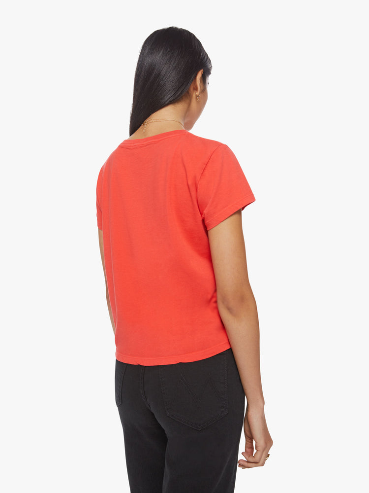 Back view of a woman bight orange-red hue slim fit crewneck with a graphic portrait and ways to trip out on the front.