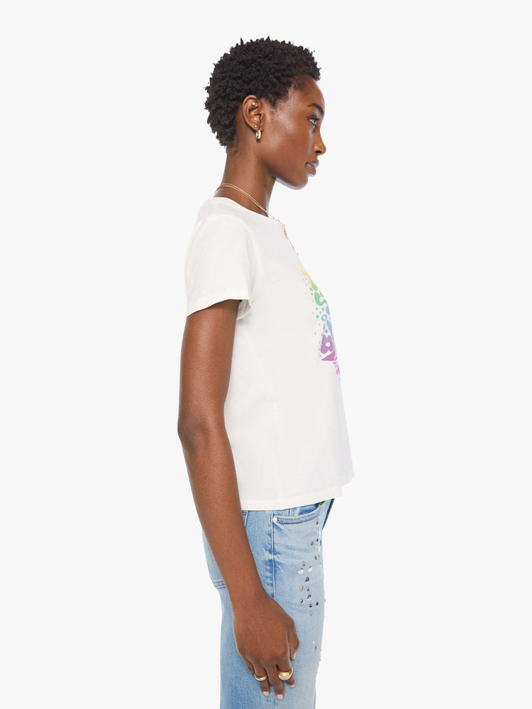 Side view of a woman bright white with a rainbow celestial graphic across the chest tee.
