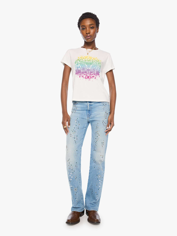 Full body view of a woman bright white with a rainbow celestial graphic across the chest tee.