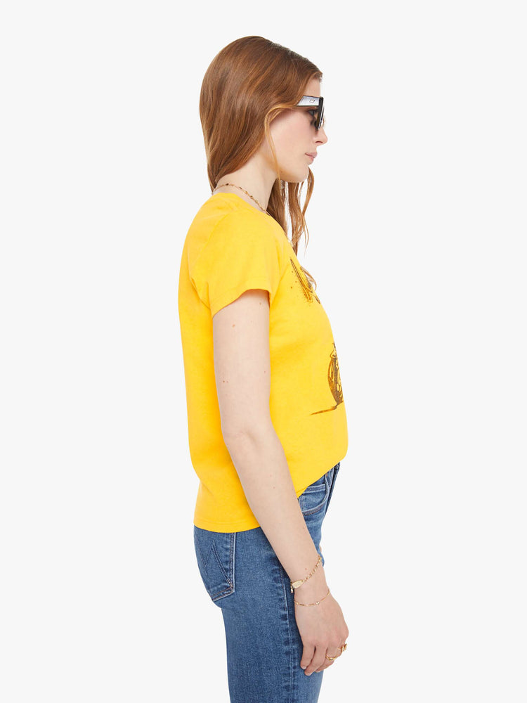 Side view of a woman in bright yellow, the tee features a bike show graphic in tan on the front.
