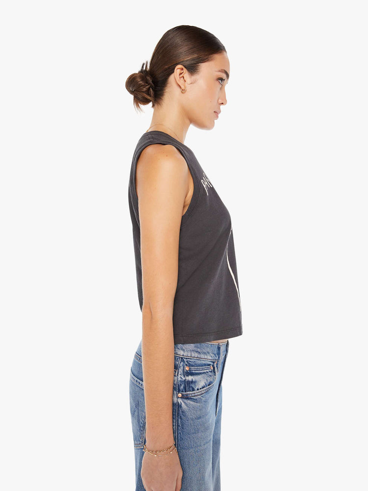 Side view of a womens faded black tank top tee featuring a cropped fit and a white graphic.