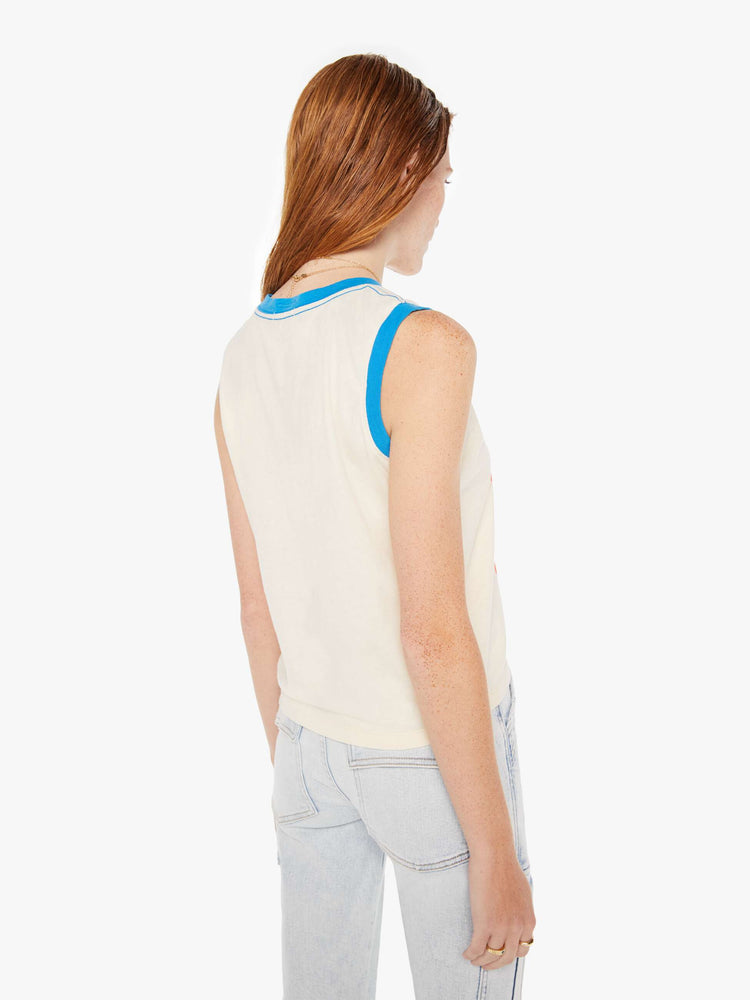 A back view of a woman wearing an off white ringer tank featuring contrast blue trim, paired with a light blue wash jean.