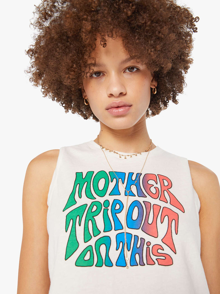 Close up view of a woman in a cropped muscle tee in white with a trippy text graphic on the front.
