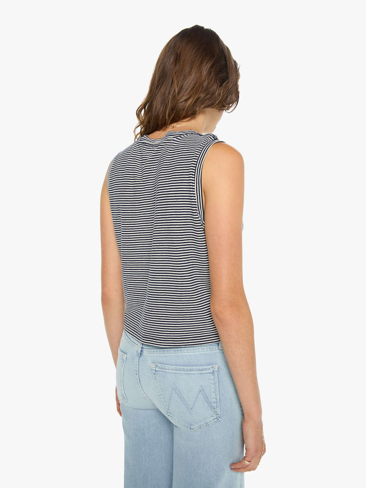 Back view of a woman in a cropped muscle tee with a crewneck and boxy fit cut from 100% cotton, in a black and white pattern