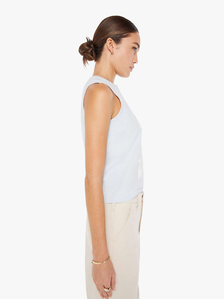 Side view of a womens light blue tank top tee featuring a cropped fit and a large white graphic.