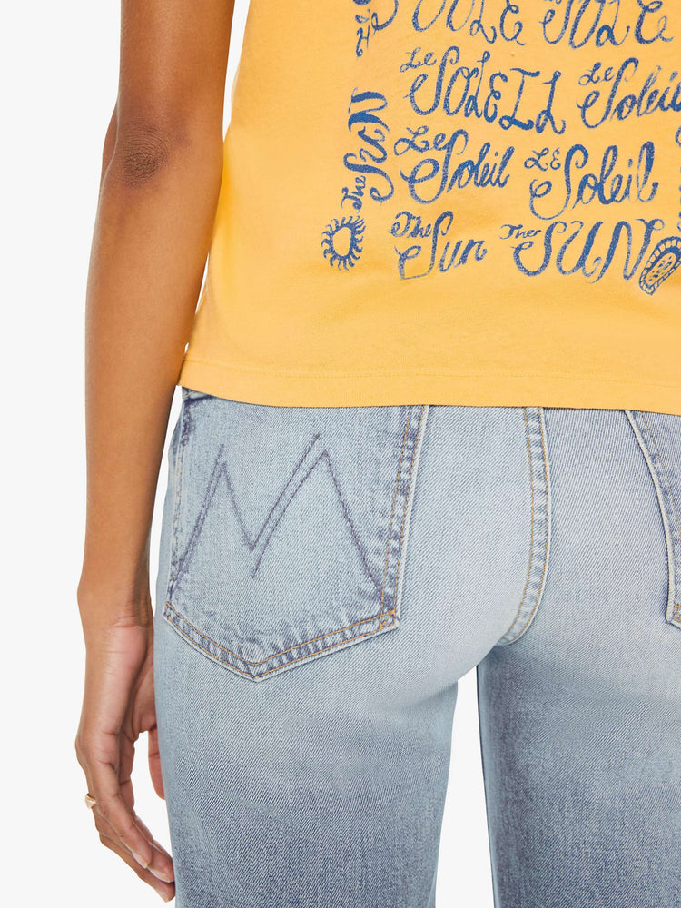 Detailed back view of a woman in a yellow cropped muscle tee that features "El Sol" text in blue.