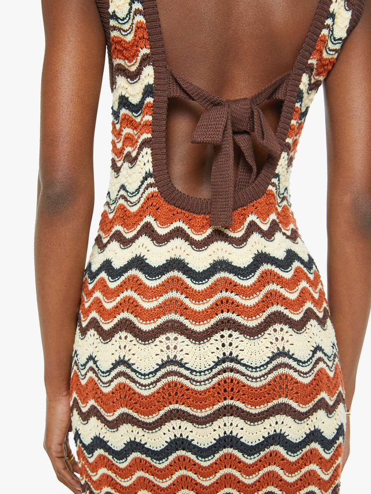 Back close up view of a woman in a striped graphic print sleeveless midi dress with a scoop neck, narrow fit and scalloped hem that hits at the calf.