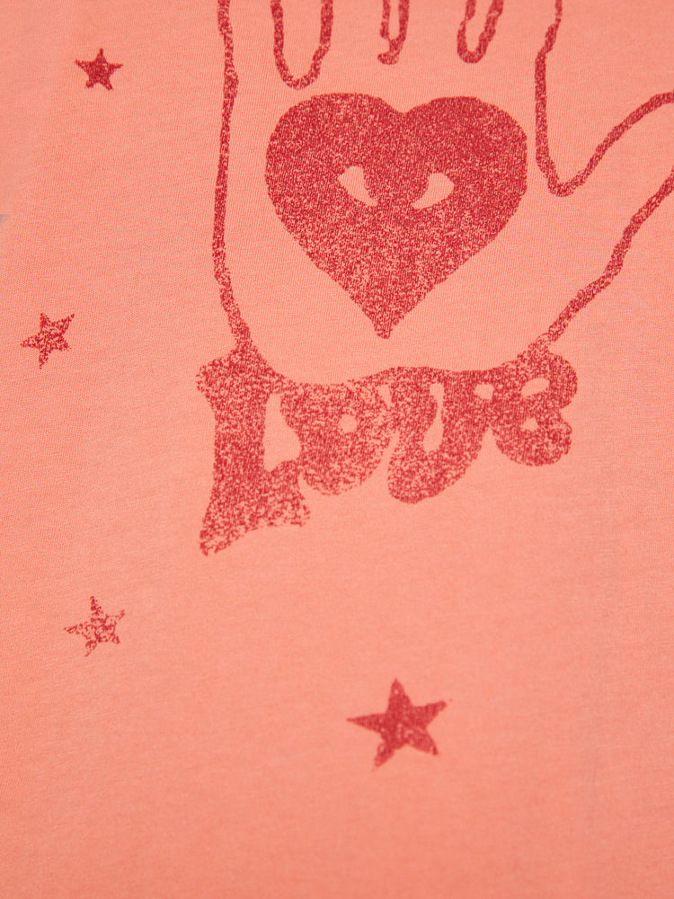 Swatch view of a woman orange tee offers a sign of love with a red hand-drawn graphic on the front.