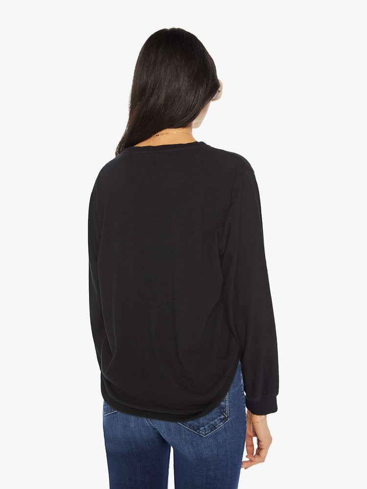 Back view of a woman black crewneck tee with long sleeves and an oversized fit.