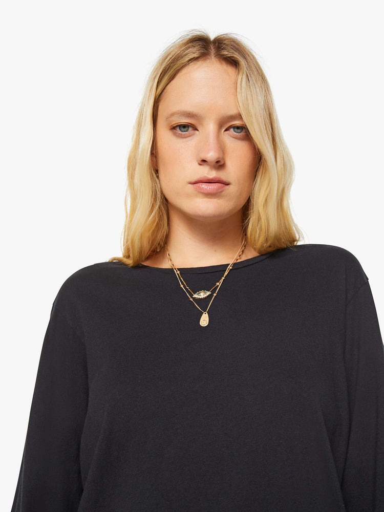 Close up view of a woman black crewneck tee with long sleeves and an oversized fit.
