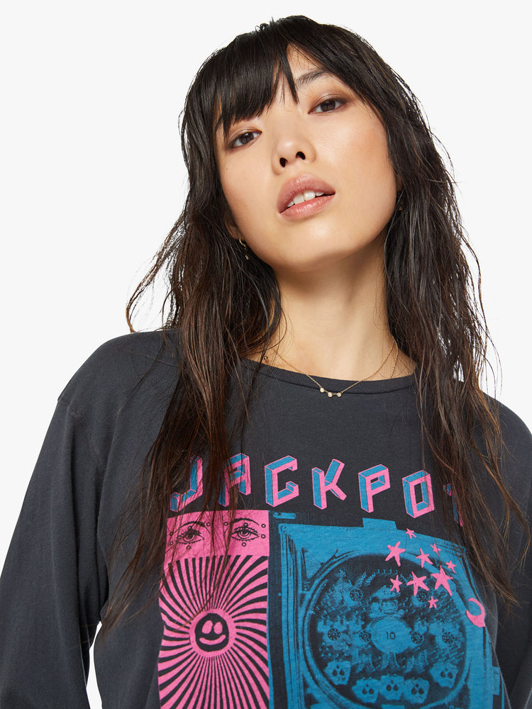 Close up view of a woman crewneck tee with an oversized fit in a faded black tee features neon pink and blue graphics inspired by a pachinko parlor.