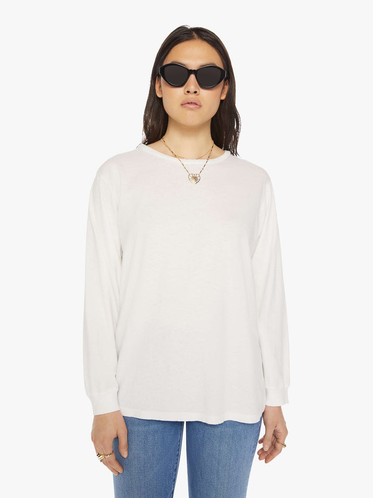 Front view of a woman crewneck tee with long sleeves and an oversized fit in a bight white hue.