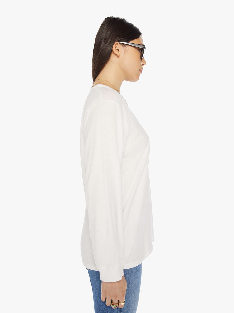 Side  view of a woman crewneck tee with long sleeves and an oversized fit in a bight white hue.