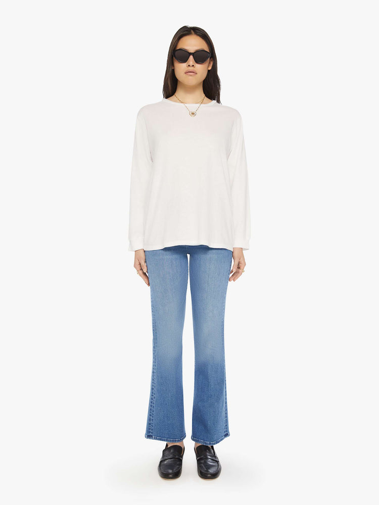 Full body  view of a woman crewneck tee with long sleeves and an oversized fit in a bight white hue.