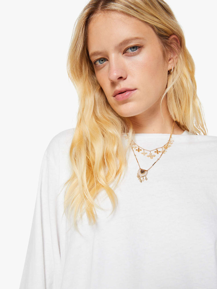 Close up  view of a woman crewneck tee with long sleeves and an oversized fit in a bight white hue.