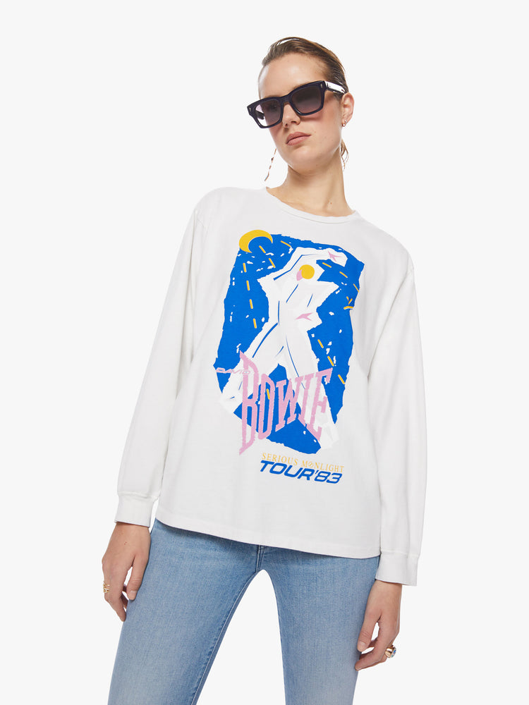 Front view of a woman oversized long sleeve tee in white, the tee features a colorful graphic that channels the electrifying spirit of the tour.