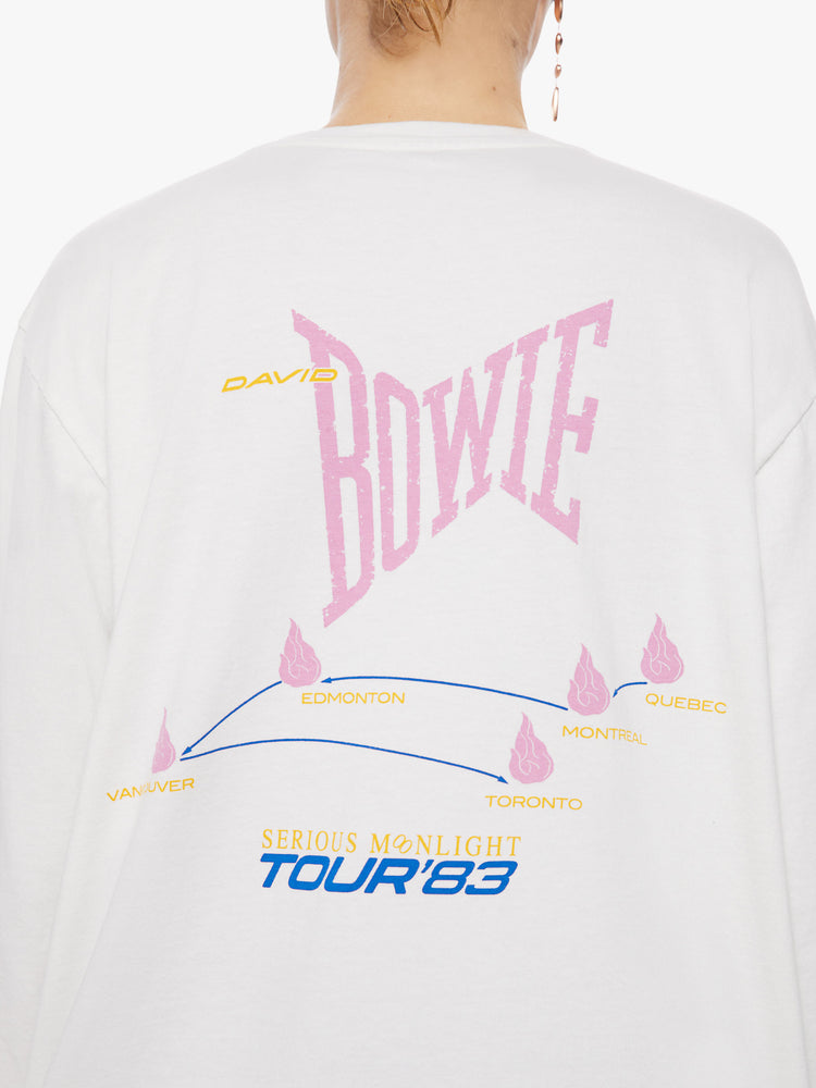 Back close view of a woman oversized long sleeve tee in white, the tee features a colorful graphic that channels the electrifying spirit of the tour.